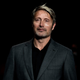 Mikkelsen, happy during a brief moment of distraction from his relationship to Coca-Cola